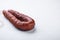 Dry cured  chorizo sausage on white textured background with copy space