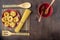 Dry fettuccine in red ceramic dishes on a background of bamboo appliances and walnut wood countertops