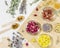 Dry flowers and herbs, tea bags and wooden spoons on wooden napkin