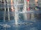 Dry fountain, water drops splashing on granite coating, close up view. Water streams flowing out of stainless grate