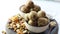 Dry fruits laddu or laddoo is placed in glass bowl on white background.