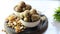 Dry fruits laddu or laddoo is placed in glass bowl on white background.