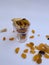 Dry Fruits like Raisin, Kishmish, Cashew and Almond filled in a transparent glass and scattered on isolated white background