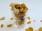 Dry Fruits like Raisin, Kishmish, Cashew and Almond filled in a transparent glass and scattered on isolated white background