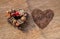 Dry fruits over on twigs pile shape of heart and Pile of coffee beans heart shape on wooden texture with background for Valentines