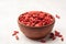 Dry goji berries in ceramic bowl on concrete background