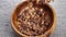 Dry granola with chocolate chips and wheat germ in wooden bowl.