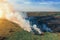 Dry grass burns, natural disaster. Forest fire aerial view. Big clouds of smoke from burning nature meadow with trees