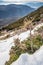 Dry grass under white clear snow on slopes at sunset, prickly plant, snowy hill, grass peek out from under snow