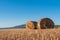 Dry hay field with a clear cut path warm color bulgaria rural landscape sun day clear blue sky