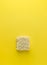 Dry instant noodles block on vibrant yellow background