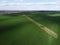 A dry irrigation canal in a sown field, aerial view. Farmland landscape