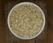 Dry oat flakes oatmeal in bowl on wooden table, sacking