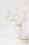 Dry oat twigs in ceramic vase burning candle on white background, styled image for social media, mockup