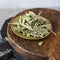 Dry olive Bay leaves in copper plate on wooden Board