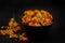 Dry orange calendula flowers in a black bowl