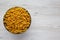 Dry Organic Maccheroni Pasta in a Bowl on a white wooden surface, top view. Flat lay, overhead, from above. Space for text