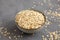 Dry Organic Rolled Oats in a Bowl on a gray background, side view