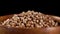 Dry organic whole grain coriander in wooden bowl. Cilantro seeds
