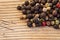 Dry peppercorn mix on wooden background