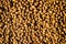 Dry pet food texture background. Food pattern. Chewing treats for pets. Isolation. Your text space.	Small brown round pieces.