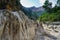 Dry river bed between mountains with large eroded rocks.