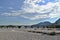 Dry riverbed with bridge, blue sky and clouds in background