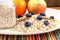 Dry rolled oatmeal flakes in bottle and plate with blueberry cinnamon and apple orange