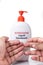 Dry skin on finger with bottle of antibacterial liquid handwash. Frequent hand washing causes skin dryness