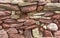 Dry stone wall with red and pink stones traditional structure with no mortar