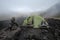 Dry Stones Pile And Tent In A Foggy Day