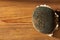 Dry sunflower with black seeds top view on a brown wooden background