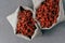 Dry superfood goji berries for healthy eating in two burlap sacks  over grey background. Food supplement. Red wolfberries