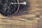 Dry tea in wooden plate on wooden table.