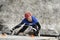 Dry tooling, training. Man in sportswear climbs on a wall using an ice axe