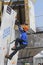 Dry tooling, training. Man in sportswear climbs on a wall using ice axes