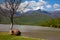 Dry tree on the riverbank, mountains, clouds.