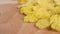 Dry uncooked corn flakes on a wooden textured surface.
