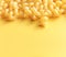 Dry uncooked italian pasta cavatappi on a yellow background with copy space