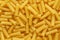 Dry uncooked tortiglioni or rigatoni pasta as a background