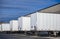 Dry vans semi trailers without of semi trucks standing in row at warehouse dock gates for loading commercial cargo for the next