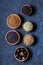 Dry whole Indian spices in wooden bowls on dark blue concrete rustic background