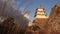 Dry winter grass and Japanese castle atop stone wall in golden light