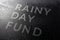 The dry words rainy day fund covered from water drops on black surface, unusual implementation concept