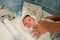 Drying of the child after a bath. bathing newborn. Cute newborn girl, a boy in a towel after a bath with his mother`s hands dryly