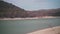 Drying lake in the mountains. Cypress trees grow at the end of the lake