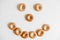 Drying or mini round bagels in the form of a smile on a white wooden background. Top view. Copy, empty space for text