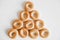 Drying or mini round bagels in the shape of a pyramid on a white wooden background. Top view. Copy, empty space for text