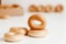 Drying or mini round bagels on a white wooden background. Copy, empty space for text