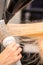 Drying straight blond hair with black hairdryer and white round brush in hairdresser salon, close up.